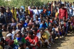 Pengungsi Ethiopia yang melarikan diri dari pertempuran di wilayah Tigray, berkumpul di pusat penerimaan perbatasan "Village 8" di negara bagian Gedaref timur Sudan, 20 November 2020.
