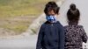 Migrant children wearing face masks to protect against coronavirus play near a refugee center near Belgrade, Serbia, March 26, 2021. 