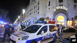 Une voiture de police est stationnée près du lieu où a eu lieu une attaque par camion qui a causé la mort de plusieurs dizaines personnes à Nice, France, 14 juillet 2016. (AP Photo / Christian Almiñana)