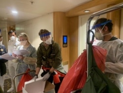 Personel medis Guardian Angels bersama para petugas dari Pusat Pengendalian dan Pencegahan Penyakit AS (CDC) bersiap memeriksa para tamu di kapal pesiar Grand Princess, di lepas pantai California, 5 Maret 2020. (Foto: Garda Nasional California via Reuters
