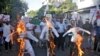 Aktivis dari All Assam Students Union (AASU) membakar patung-patung yang menggambarkan Menteri Dalam Negeri India Amit Shah, Perdana Menteri Narendra Modi dan Ketua Menteri Assam Sarbananda Sonowal selama protes terhadap RUU Amandemen Kewarganegaraan. (Foto: Reuters)