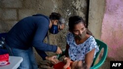 A child is vaccinated in Barcelona, Anzoategui State, Venezuela, March 16, 2021. In Venezuela there are people who had malaria up to 20 times.