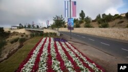 Flores decoradas como una bandera estadounidense a lo largo de una calle que lleva al complejo de la embajada de EE.UU. en Jerusalén en anticipación a la inauguración oficial el domingo, 13 de mayo, de 2018.
