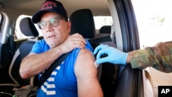 Jeffrey Dillon receives a Pfizer COVID-19 vaccine booster shot at the Dallas County Health and Human Services drive-up vaccine site in Mesquite, Texas, Nov. 30, 2021. (AP Photo/LM Otero)