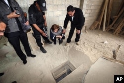 In this photo provided by Mexico's attorney general, authorities inspect the exit of the tunnel they claim was used by drug lord Joaquin "El Chapo" Guzman to break out of the Altiplano maximum security prison in Almoloya, west of Mexico City, July 12, 201