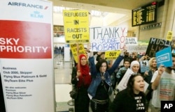FILE - Demonstrators opposed to President Donald Trump's travel ban march through Tom Bradley International Terminal at Los Angeles International Airport, Feb. 4, 2017.