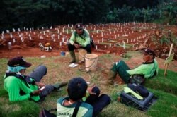 Para petugas penggali kuburan beristirahat di sebuah kompleks pemakaman jenazah pasien Covid-19, di Jakarta. (Foto: Reuters)
