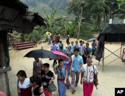 FILE - Karen refugees leave after a church service at Mae La refugee camp in Ta Song Yang district of Tak province, northern Thailand.