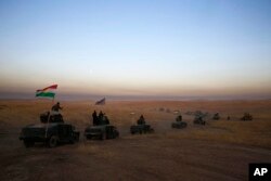 FILE - A peshmerga convoy drives towards a frontline in Khazer, about 30 kilometers (19 miles) east of Mosul, Iraq, Oct. 17, 2016.
