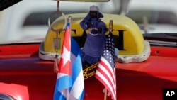 Bendera Amerika dan Kuba disandingkan di dashboard sebuah mobil di Havana, Kuba, 18 Februari 2016.