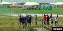 Peserta Jambore Pramuka Sedunia ke-25 berkumpul di zona pasokan air di lokasi perkemahan di Buan. (Foto: Yonhap via Reuters)