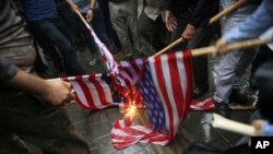 ARSIP – Foto yang diambil hari Rabu, 9 Mei 2018 menunjukkan para pengunjuk rasa Iran membakar bendera AS selama unjuk rasa di lokasi bekas Kedubes AS sebagai tanggapan atas keputusan Presiden Donald Trump untuk menarik diri dari kesepakatan nuklir dan kembali menerapkan sanksi di Teheran (foto: AP Photo/Vahid Salemi)