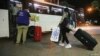Una trabajadora doméstica migrante de África lleva su equipaje hacia un autobús que la llevaría con otras personas al aeropuerto para regresar a sus países de origen, en un suburbio de Beirut, Líbano, el 5 de octubre de 2020.