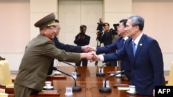 韩国总统的国家安全顾问金宽镇(右)与朝鲜军队的最高政治官（左）握手。