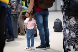 FILE - Afghan refugees who supported Canada’s mission in Afghanistan wait to board buses after arriving in Canada at Toronto Pearson International Airport in Mississauga, Ontario, Aug. 13, 2021.