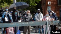 La gente reza durante una misa católica celebrada fuera de un banco de alimentos en la Iglesia de San Bartolomé, durante el brote de la enfermedad por coronavirus (COVID-19 en Nueva York, EE.UU. )