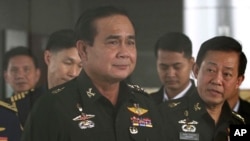 Thailand's Army commander Gen. Prayuth Chan-ocha, left, arrives at the Royal Thai Army Club in Bangkok, Thailand, June 13, 2014. 
