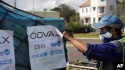 FILE - A worker handles the cargo of COVID-19 vaccines, donated through the U.N.-backed COVAX program in Madagascar, May 8, 2021.