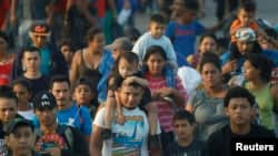 FILE - Hundreds of Central American migrants walk together on the highway, after crossing the Guatemala-Mexico border, near Ciudad Hidalgo, Mexico, June 5, 2019.