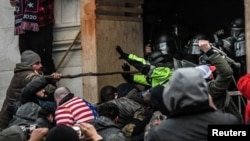 Los partidarios del presidente de los Estados Unidos, Donald Trump, se enfrentan a la policía en la entrada oeste del Capitolio durante una protesta "Stop the Steal" frente al edificio del Capitolio en Washington DC, el 6 de enero de 2021.