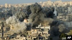 El humo se levanta de una explosión causada por un ataque aéreo israelí en un edificio del centro cultural Said al-Mis'hal en la ciudad de Gaza, el jueves 9 de agosto de 2018. Funcionarios palestinos dicen que aviones de combate israelíes atacaron el centro cultural en la ciudad de Gaza. El Ministerio de Salud palestino dice que siete transeúntes resultaron heridos en el ataque aéreo del jueves por la noche en el campo de refugiados de Shati. (AP Photo / Arafat Kareem)
