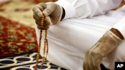 A worshipper wearing surgical gloves to prevent the spread of the coronavirus prays at al-Mirabi Mosque in Jiddah, Saudi Arabia, May 31, 2020. 