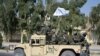 Pasukan Taliban dari Korps Militer Al-Badr duduk di atas kendaraan bersenjata dalam sebuah parade di Kandahar, Afghanistan, pada 8 November 2021. (Foto: AFP/Javeed Tanveer)