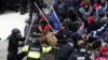Los manifestantes pro-Trump derriban una barricada mientras chocan con la policía del Capitolio durante un mitin para impugnar la certificación de los resultados de las elecciones presidenciales de los EE. UU. 2020 por parte del Congreso de los EE. UU.