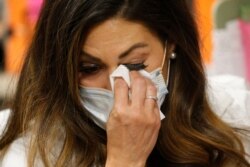 Health investigator Maria DiCaro wipes her eyes after chatting by phone at her office at the Salt Lake County Health Department, in Salt Lake City, with a person who had been exposed to the coronavirus, May 11, 2020.