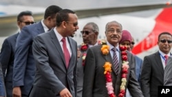 Le ministre des Affaires étrangères de l'Erythrée, Osman Sale (centre) est accueilli par le Premier ministre éthiopien Abiy Ahmed (gauche) à l'arrivée de la délégation érythréenne à l'aéroport d'Addis-Abeba, Ethiopie, le 26 juin 2018.