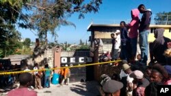 People stand outside the Orphanage of the Church of Bible Understanding where a fire broke out the previous night in the Kenscoff area outside Port-au-Prince, Haiti, Feb. 14, 2020. 