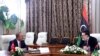 FILE - Turkey's Foreign Minister Mevlut Cavusoglu, right, and Fayez Sarraj, the head of Libya's internationally-recognized government, speak during a meeting in Tripoli, Libya, June 17, 2020.